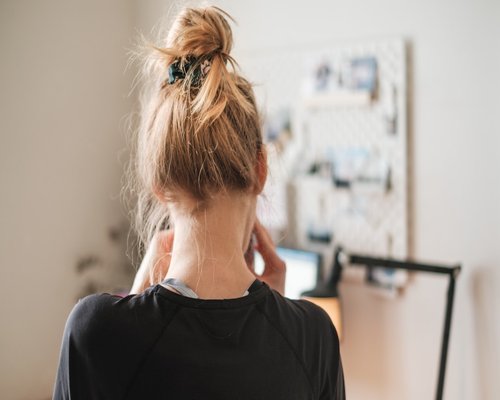 Woman stretching at her desk in a home office