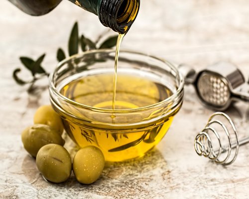 Fresh vegetables and olive oil on a wooden table
